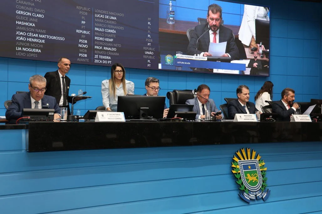 Parlamentares e servidores na mesa do plenário da Assembleia Legislativa de Mato Grosso do Sul durante uma sessão.