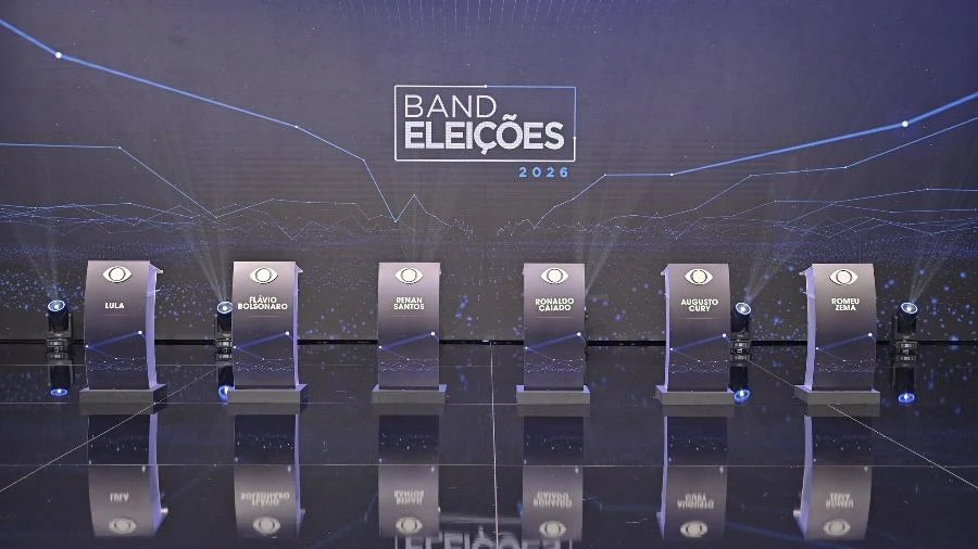 Estúdio da Band com seis púlpitos vazios identificados com nomes de candidatos e painel Band Eleições 2026 ao fundo, em registro do primeiro turno.