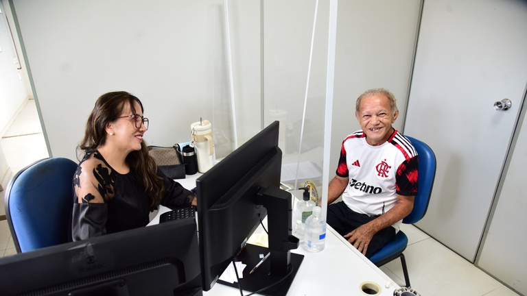 Assistente social do INSS conversa com um homem durante atendimento em uma agência da Previdência Social. Foto de arquivo.